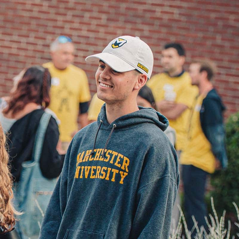 A student wearing an MU hoodie smiles.