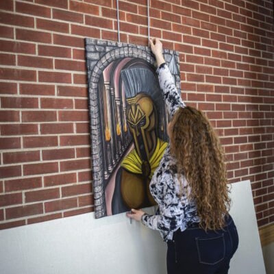 Art student hanging art of mascot spartan